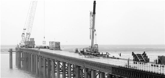 昨天，在寧?？h三門灣跨海大橋海上建設工地，工人們正在連接長40米的鋼管樁，為建造橋墩作準備。目前，概算投資126億元的三門灣跨海大橋及接線工程前期施工進展順利，將于下月起全面進入海上、全線隧道、樁基、路基工程建設。